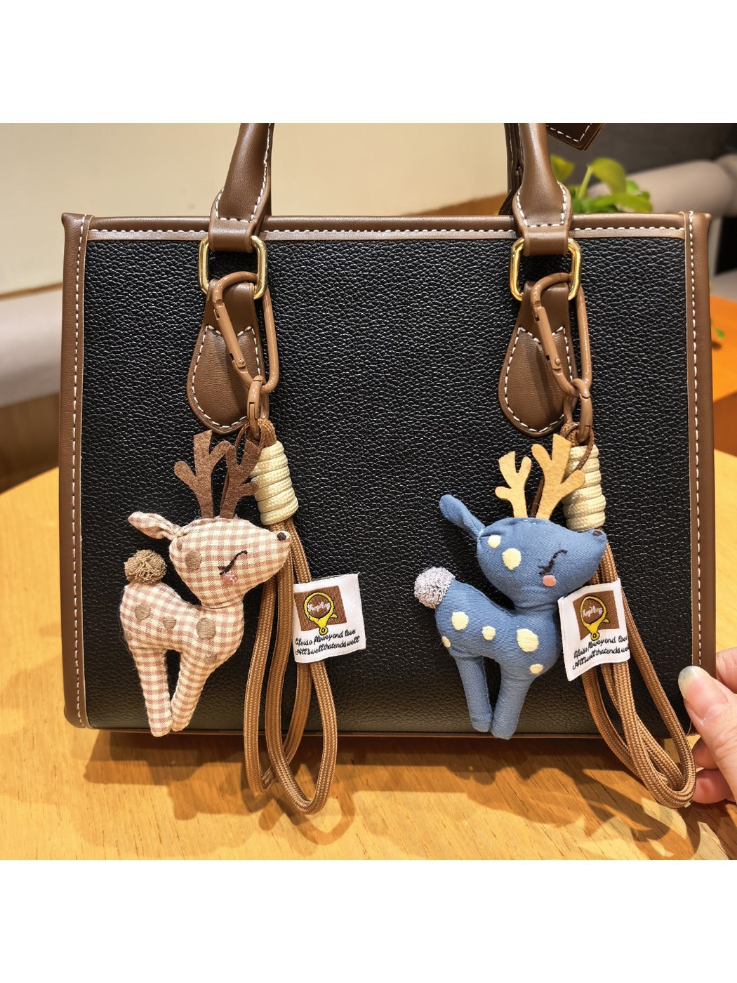 Close-up of Keypus cute deer charm keychain with brown and white enamel finish