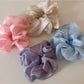 Scrunchie wrapped around a ponytail on a model with soft romantic styling