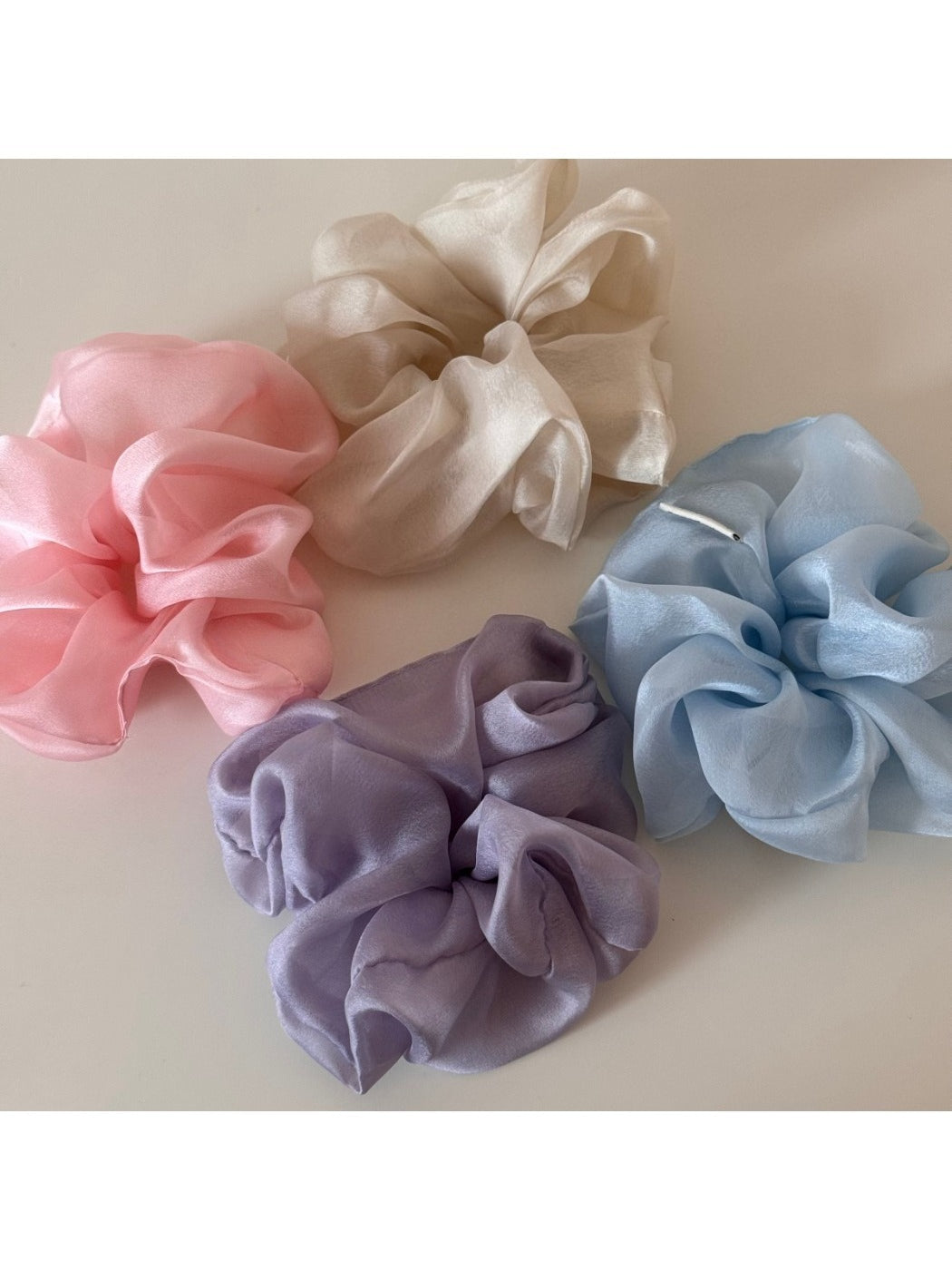 Scrunchie wrapped around a ponytail on a model with soft romantic styling