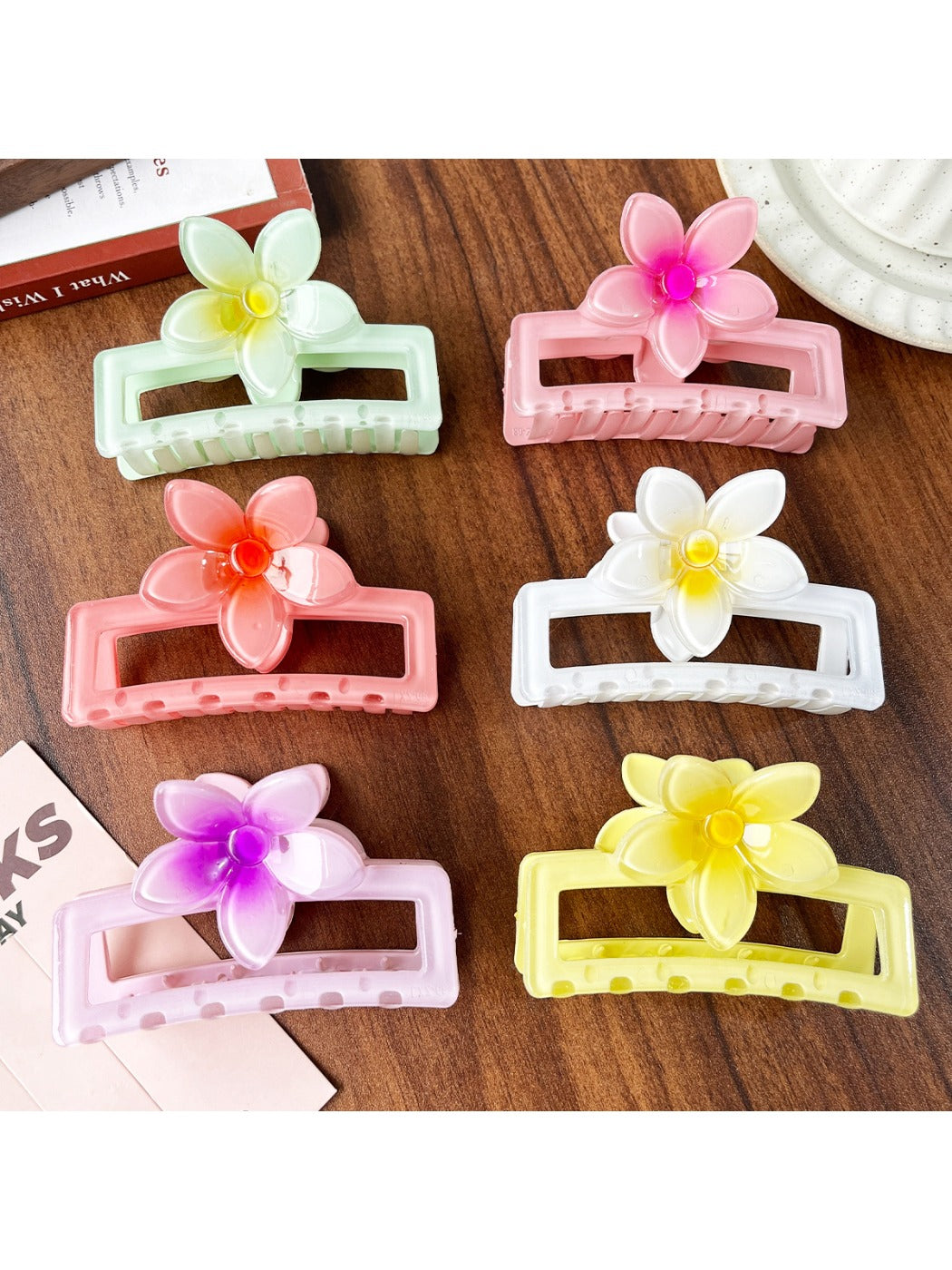 Beau square ombre flower shaped claw clip in pink and purple gradient on white background
