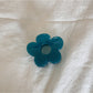 Top view of beige flower shaped claw clip showing symmetrical petals