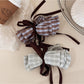 Close-up of Beau delicate bow shaped hair clip in soft pink fabric