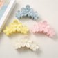 Bright flower-shaped hair clip with yellow petals and a central pearl detail