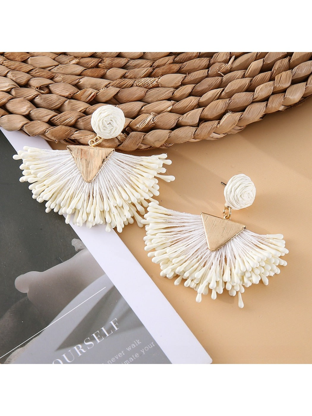 Flat lay of earedge raffia drop earrings with natural elements and accessories