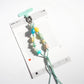 Resin bead keychain displayed on a wooden surface with natural light