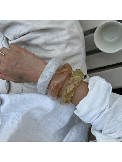 Side view of Lovra irregular shaped bangle bracelet emphasizing its thickness and curves