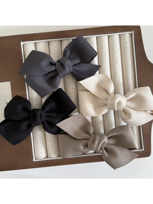 Beau solid satin bow hair clip on white background showing front view