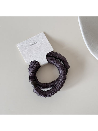 Model with long hair wearing Gifty satin hair tie styled in a low bun