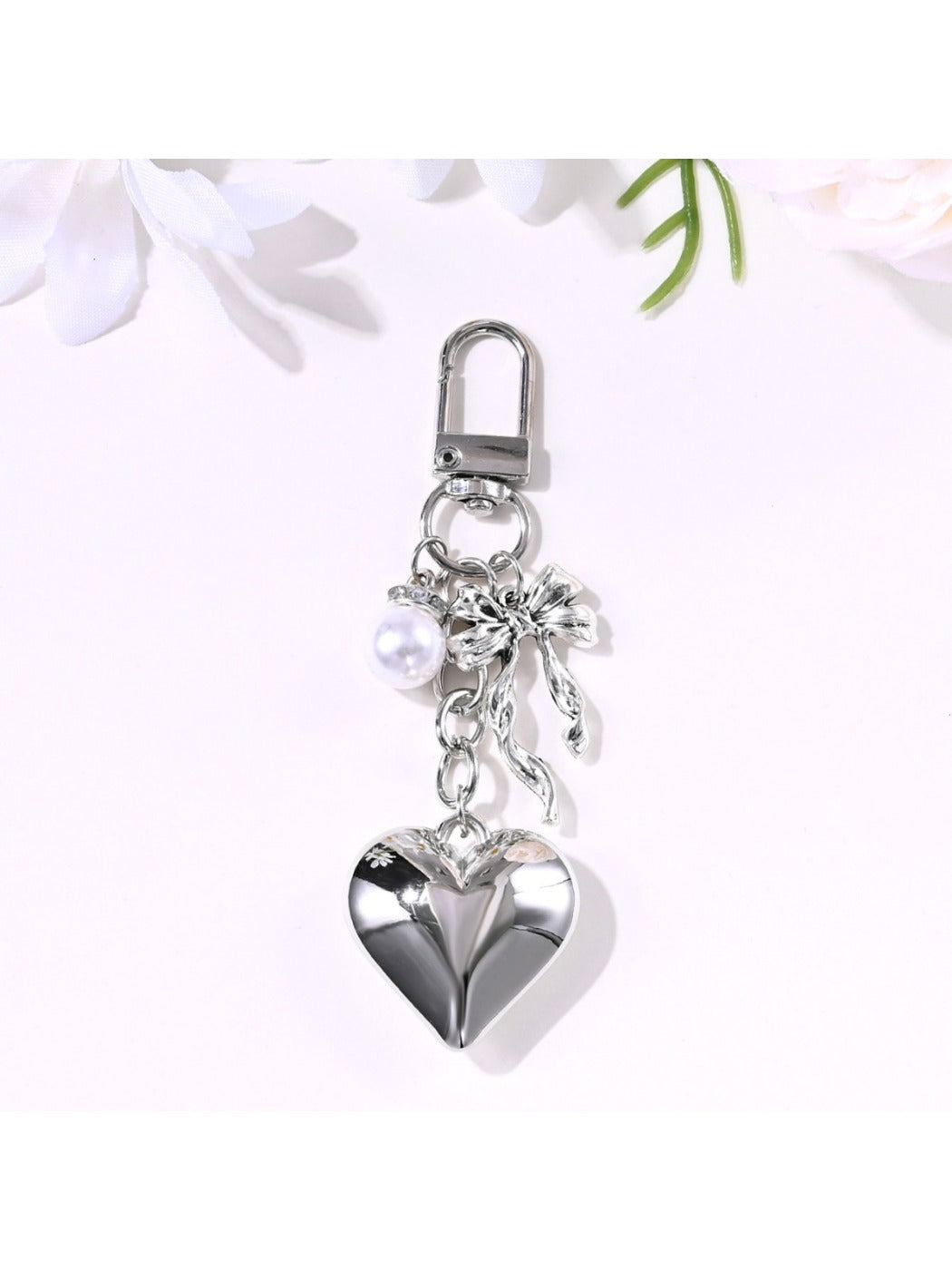 Alloy heart-shaped keychain with a bow detail on a white background