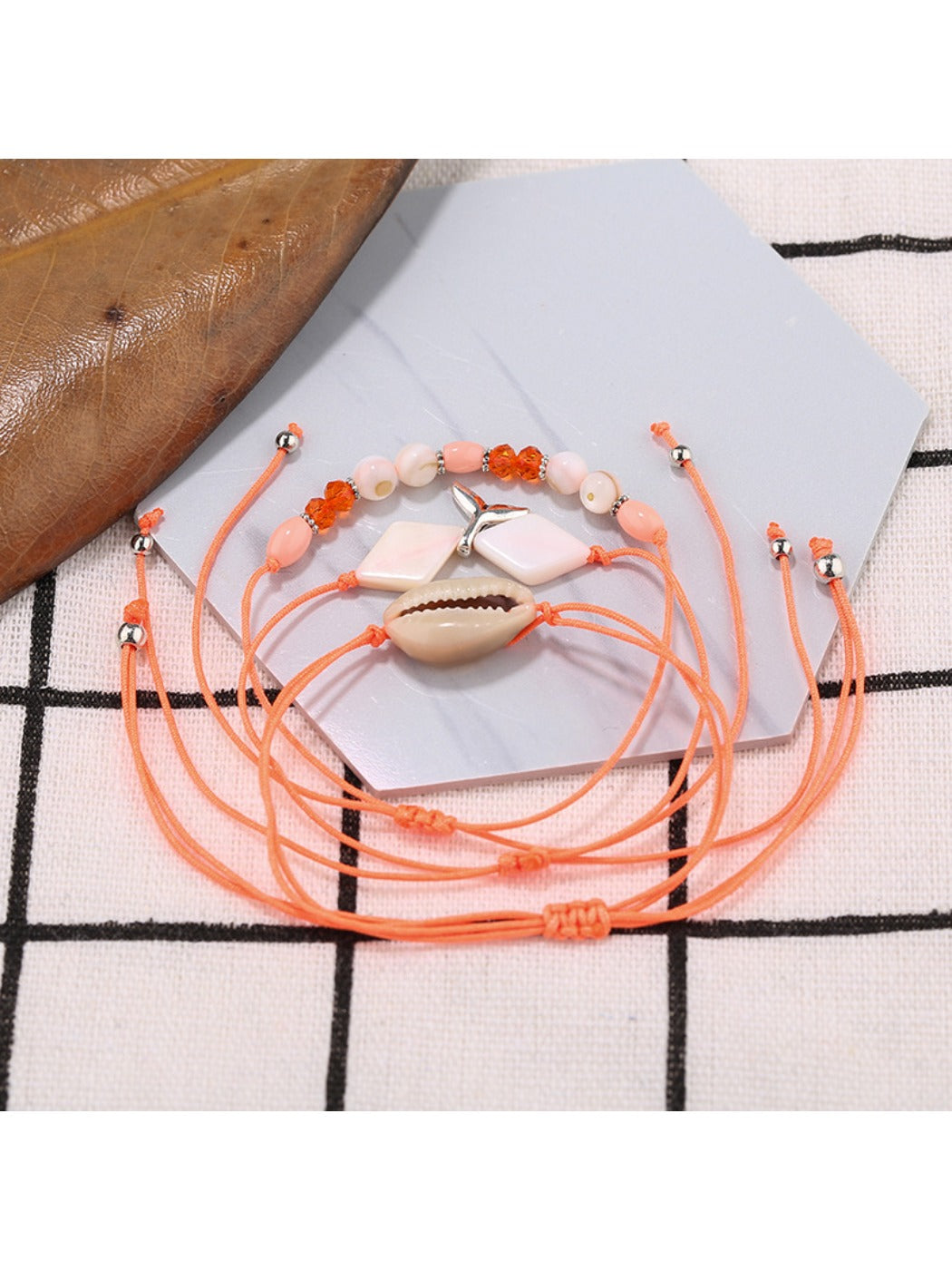 Lovra small bead bracelet with mermaid tail charm in natural light