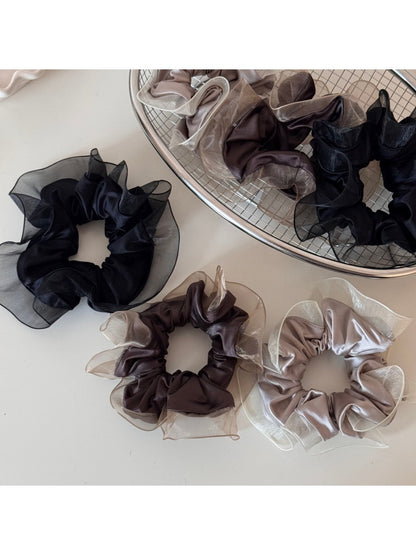 Close-up of glossy scrunchie fabric showing its silky finish