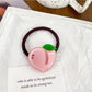 Set of colorful fruit-themed hair ties packaged in a clear plastic box