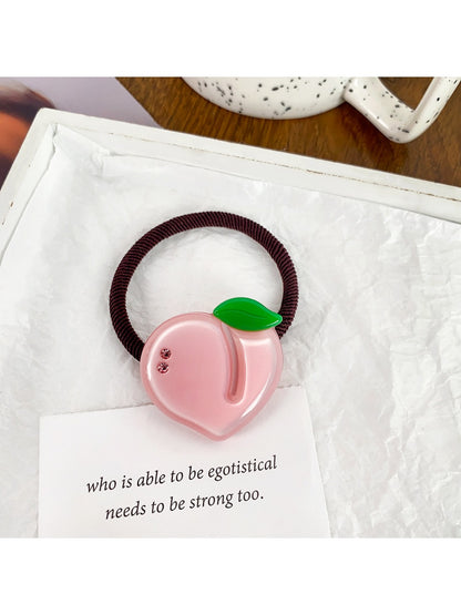 Set of colorful fruit-themed hair ties packaged in a clear plastic box