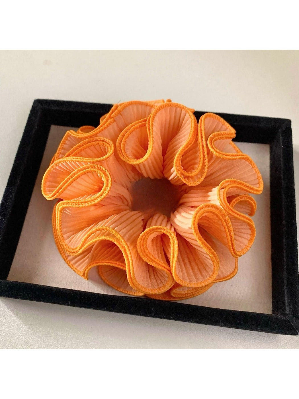 Multiple Gifty ruffle scrunchies stacked together in different solid colors