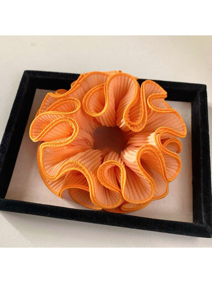 Multiple Gifty ruffle scrunchies stacked together in different solid colors