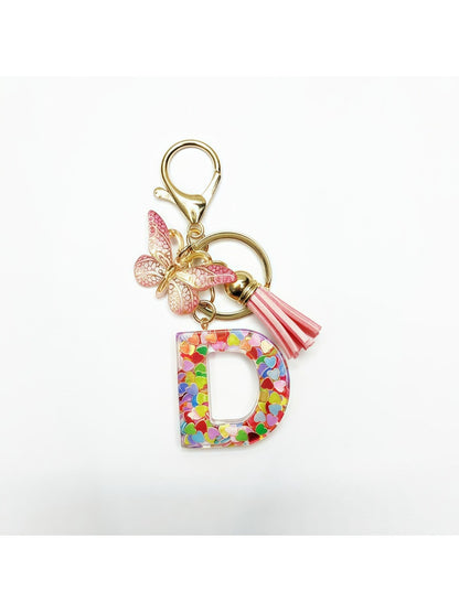 Letter pendant with butterfly charm on a silver keyring on a marble surface