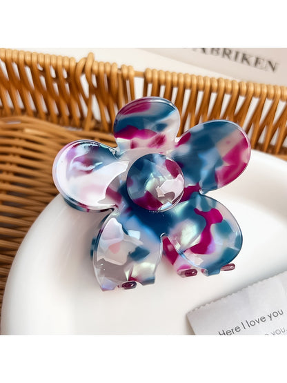 Colorful flower-shaped hair claw clip displayed against a neutral background