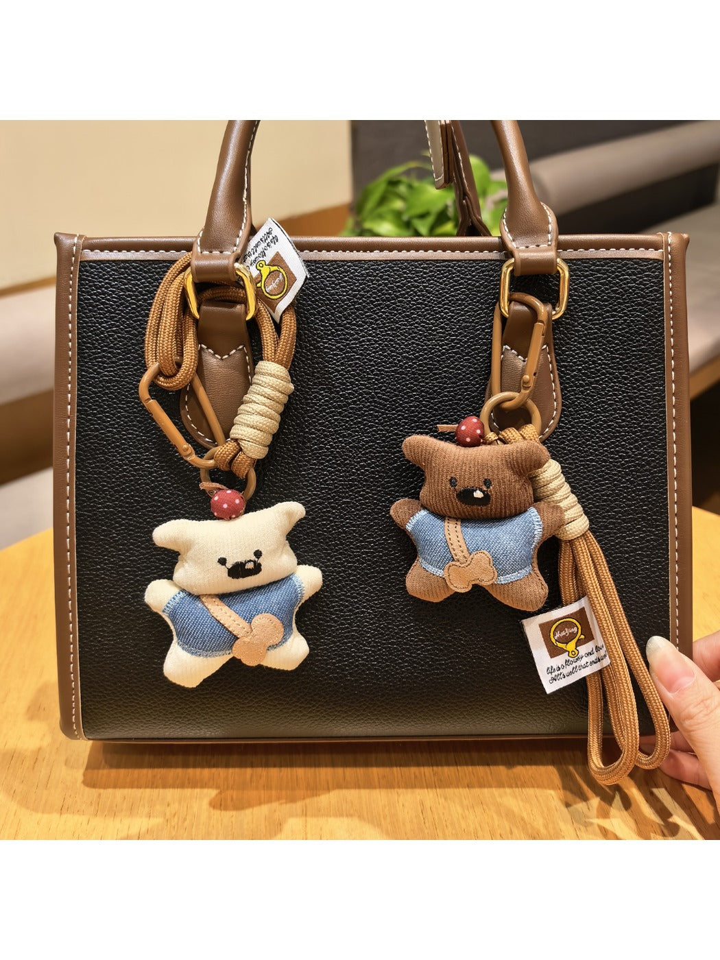 Fabric little bear shaped keychain with stitched details on a white background