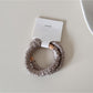 Gifty satin hair tie gently twisted to show flexibility and smooth finish