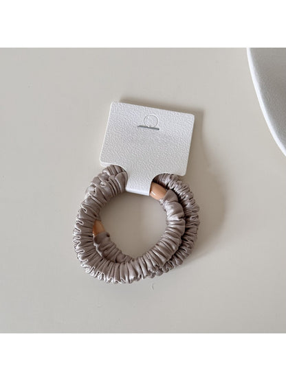 Gifty satin hair tie gently twisted to show flexibility and smooth finish