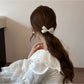 Gifty hair tie worn on wrist displaying bow and floral pattern