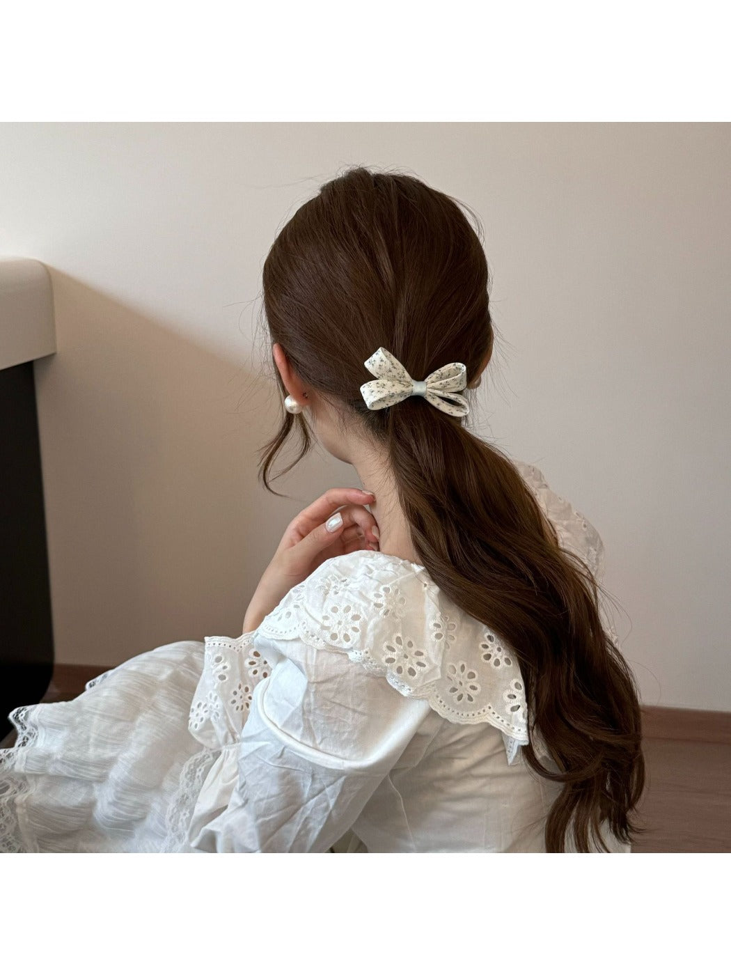 Gifty hair tie worn on wrist displaying bow and floral pattern