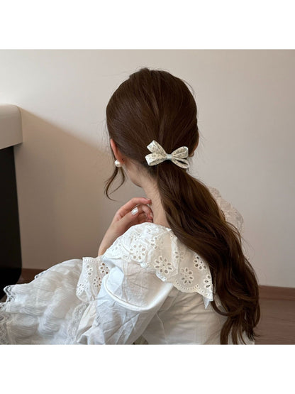 Gifty hair tie worn on wrist displaying bow and floral pattern