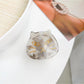Beau hair claw clip resting on fabric surface, angled view