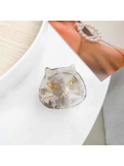 Beau hair claw clip resting on fabric surface, angled view