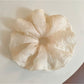 Close-up of a minimalist thin solid color scrunchie in soft fabric