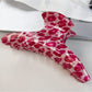 Beau pink leopard print half round claw clip with metal spring mechanism visible