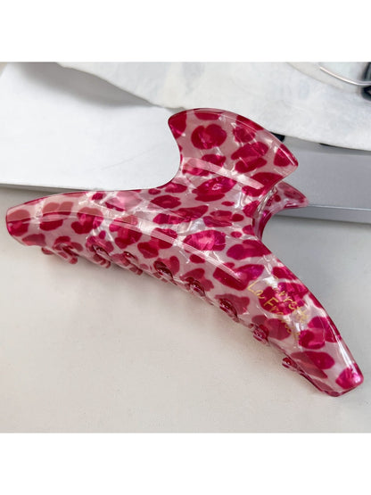 Beau pink leopard print half round claw clip with metal spring mechanism visible