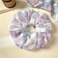 Gifty scrunchie wrapped around a ponytail on a model with casual outfit