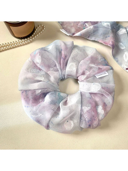 Gifty scrunchie wrapped around a ponytail on a model with casual outfit