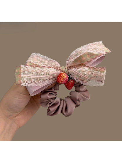 Model wearing Gifty Strawberry Charm Lace Bow Scrunchie in hair with visible red strawberry charm and lace bow