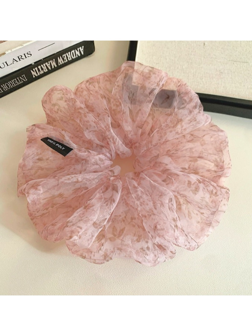 Pink tulle scrunchie styled on a wrist with visible floral design