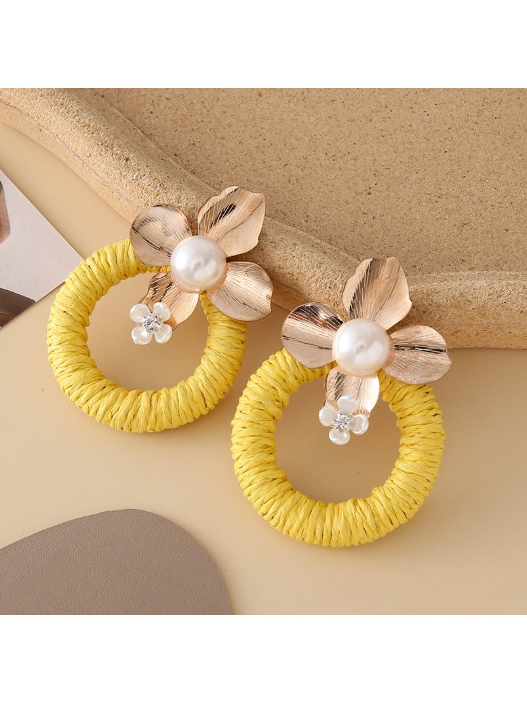 Earedge round floral pendant earrings placed on a wooden surface