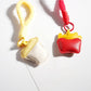Close-up of Keypus keychain showing detailed fries and coffee cup charm