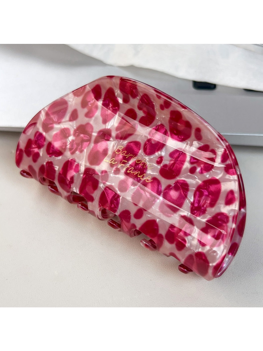 Beau pink leopard print half round claw clip next to matching hair accessories