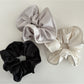 Side view of Gifty satin scrunchie highlighting its gathered silky fabric