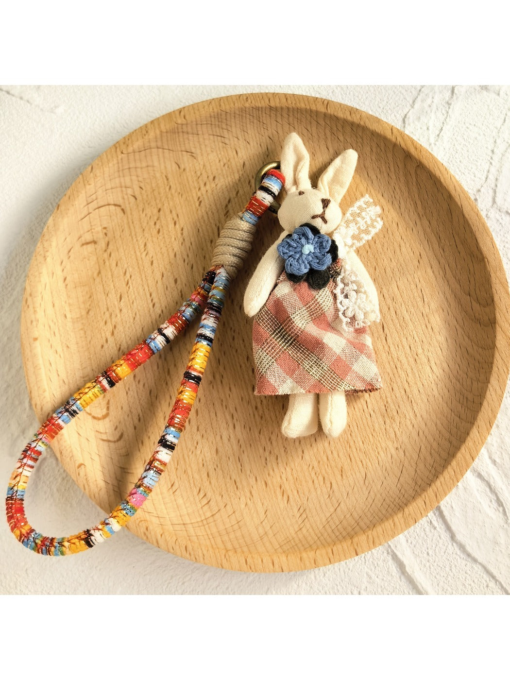 Keypus fabric doll keychain hanging from a backpack strap
