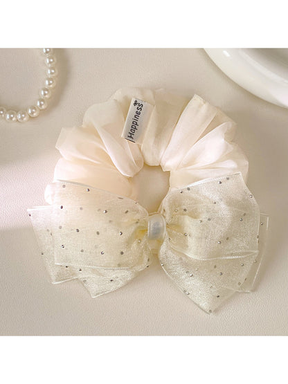 Close-up of pink tulle fabric and bow detail on scrunchie