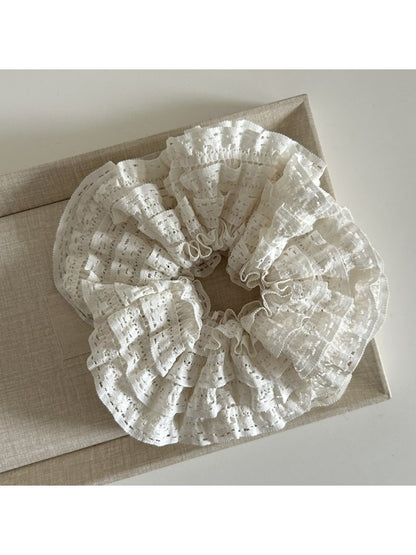 Gifty Sweet Cutout Lace Scrunchie styled in long hair, showcasing its delicate lace pattern