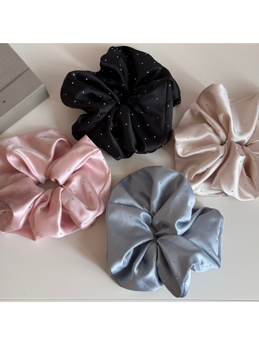 Gifty satin scrunchie with rhinestone decoration displayed on a white background