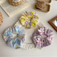 Side view of Gifty Ribbon Bow Plaid Scrunchie highlighting the bow and elastic band