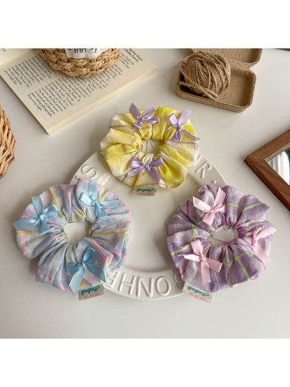 Side view of Gifty Ribbon Bow Plaid Scrunchie highlighting the bow and elastic band