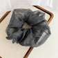 Pink polka dot scrunchie stretched to show elasticity and soft tulle material