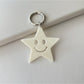 Star pendant keychain resting on a textured fabric surface