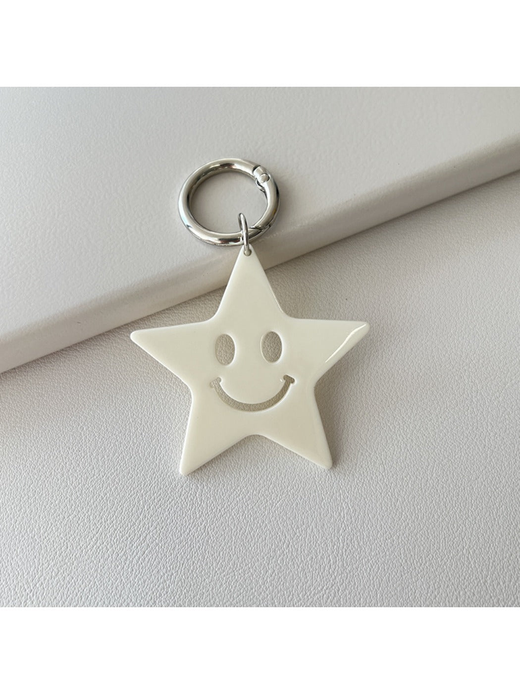 Star pendant keychain resting on a textured fabric surface