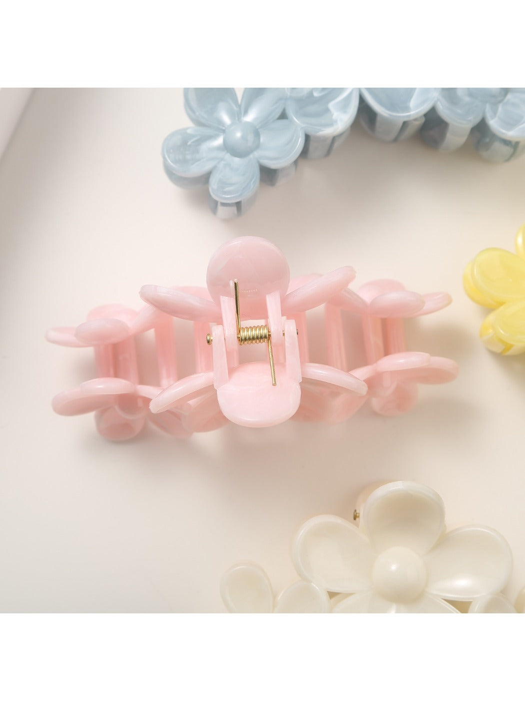 Close-up of yellow flower hair clip showing petal texture and pearl center